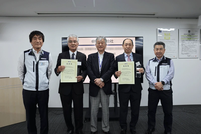 Supplier representatives shown with certificates of recognition